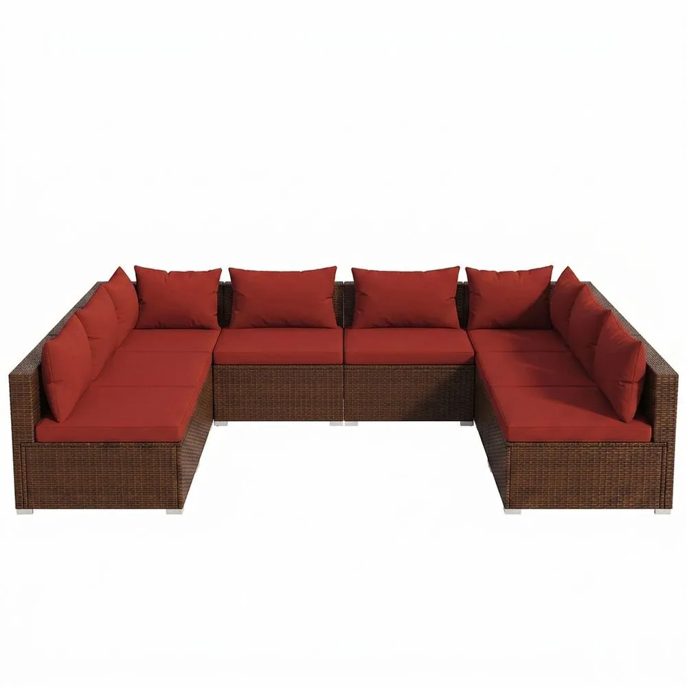 Un conjunto de sofá esquinero de ratán con cojines rojos.