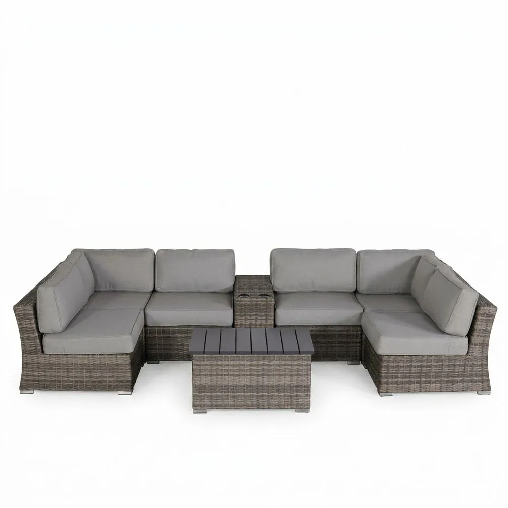 Conjunto de muebles de jardín de ratán sintético con cojines grises.