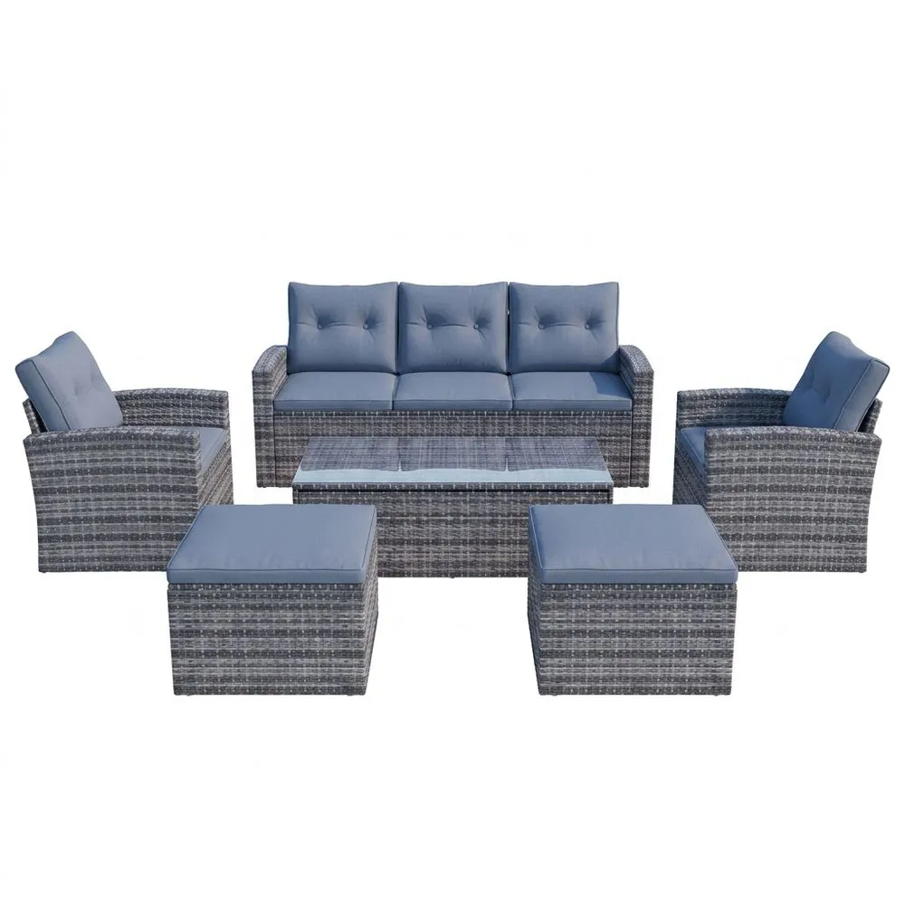 Conjunto de muebles de jardín de ratán sintético gris con cojines azules.