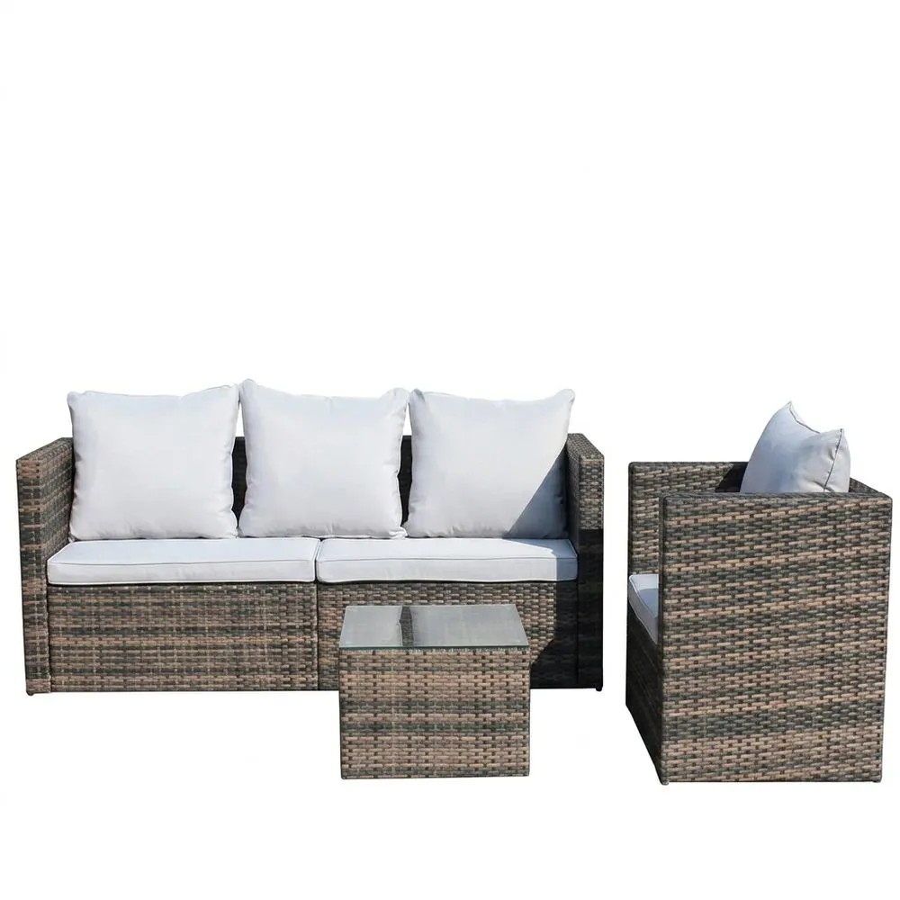 Un conjunto de muebles de jardín de ratán con cojines blancos y una mesa de cristal.