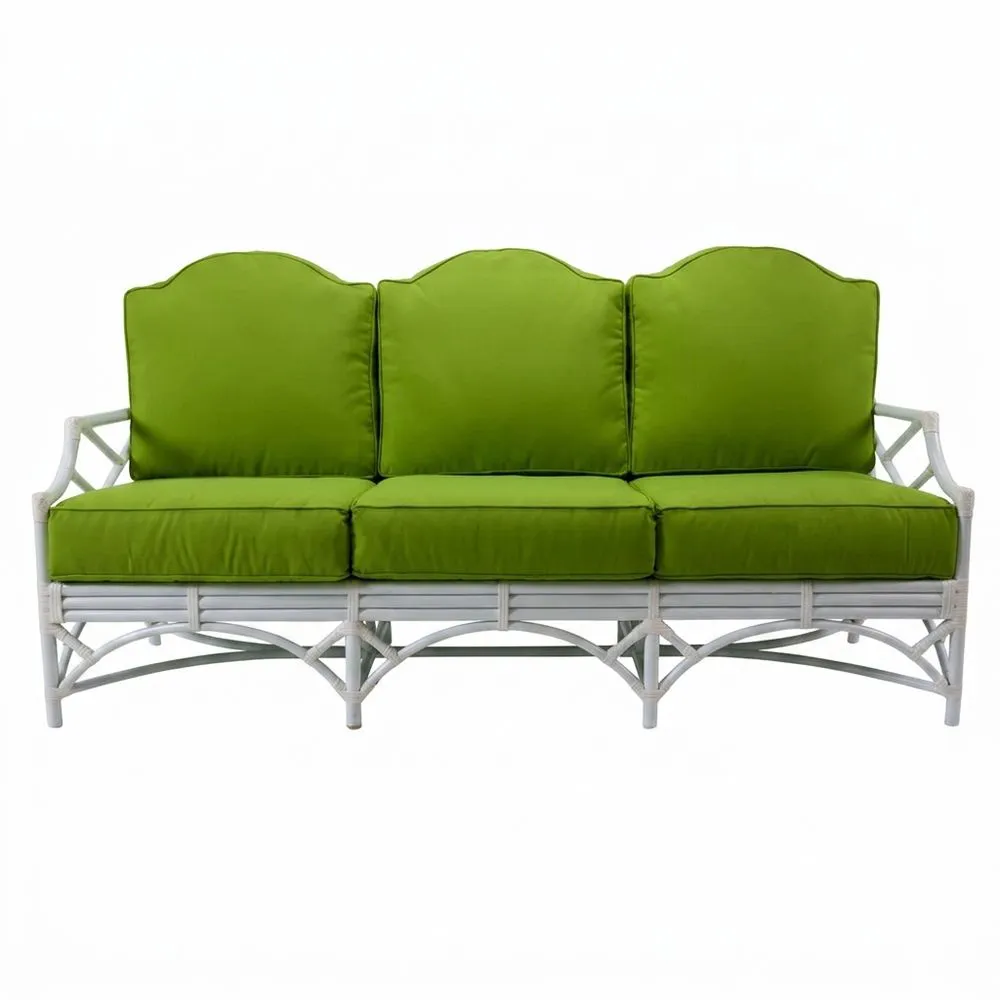 Sofá de ratán con cojines de poliéster verde.