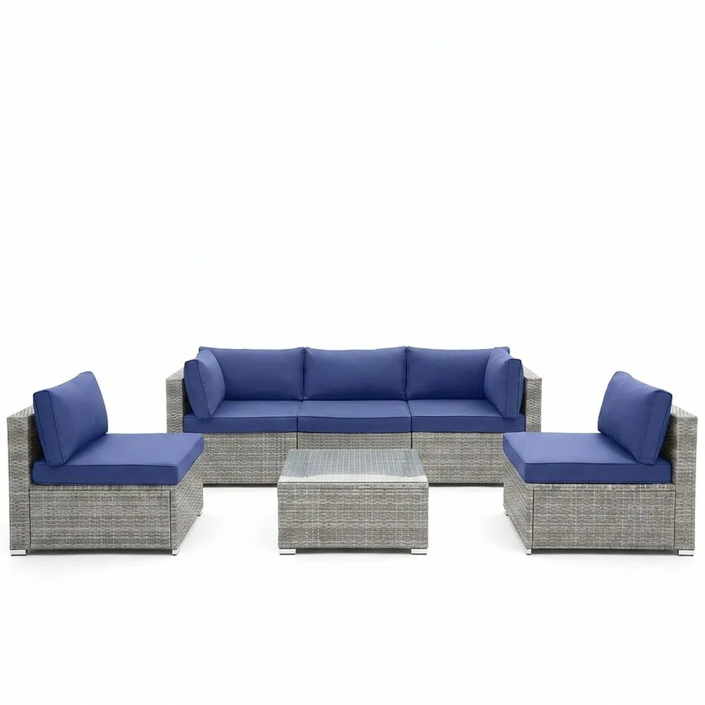 Conjunto de muebles de ratán sintético, con cojines y mesa azules.