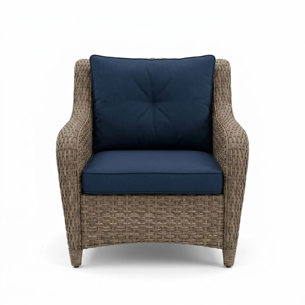 Sillón de ratán sintético con cojín de asiento azul.