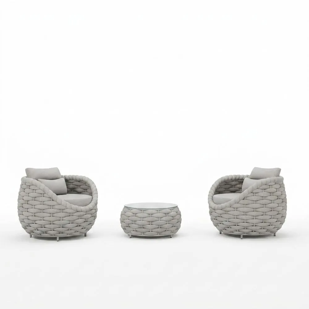 Conjunto de tres piezas de muebles de exterior, fabricados en polietileno tejido gris, con cojines.