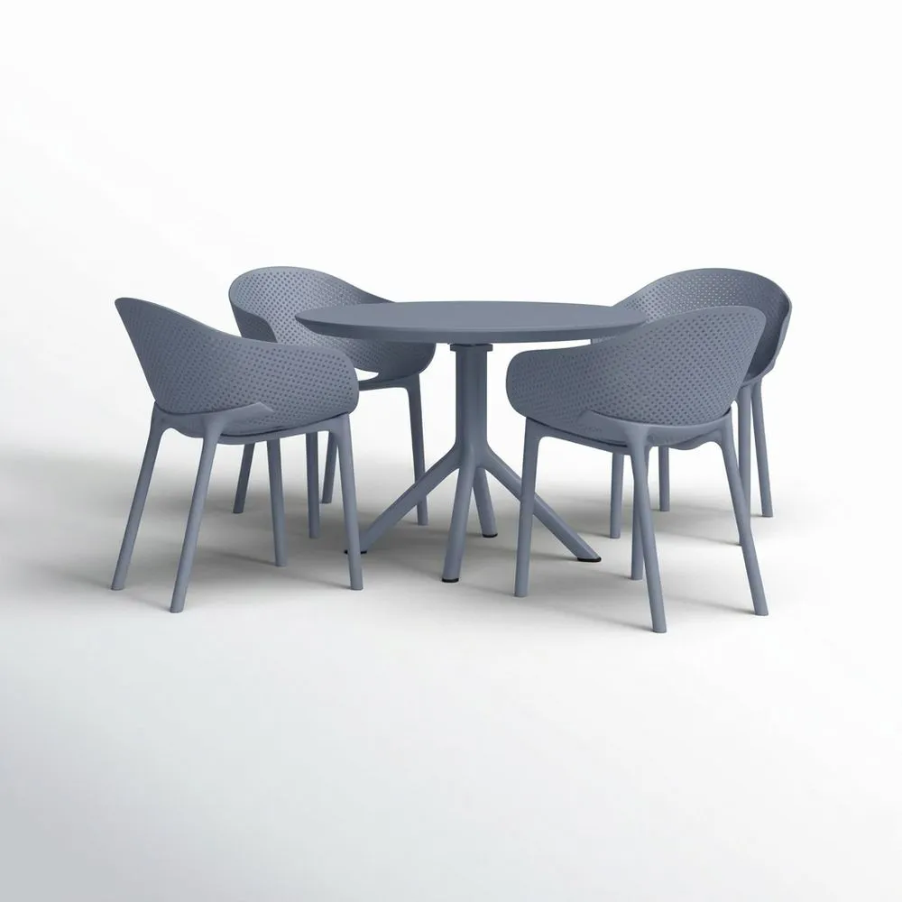 Una mesa redonda de plástico gris y cuatro sillas.