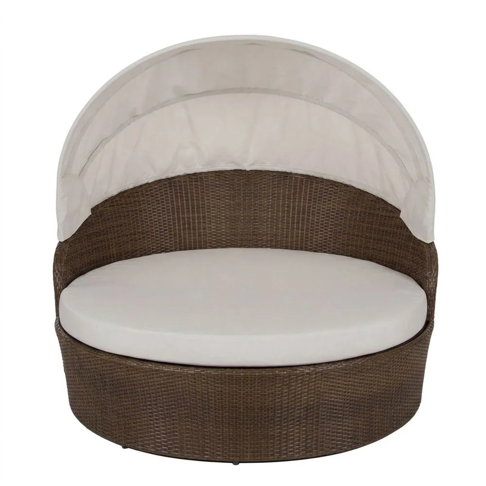 Sofá redondo de ratán marrón con cojín y toldo blanco para exterior