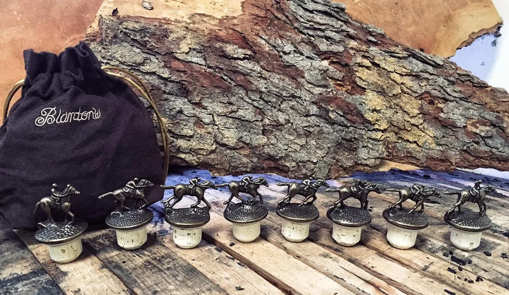 Eight collectible racing horse bottle stoppers spelling BLANTON'S