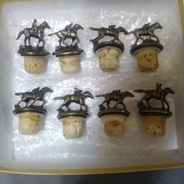 Eight horse-and-jockey bottle stoppers shown as the complete physical set