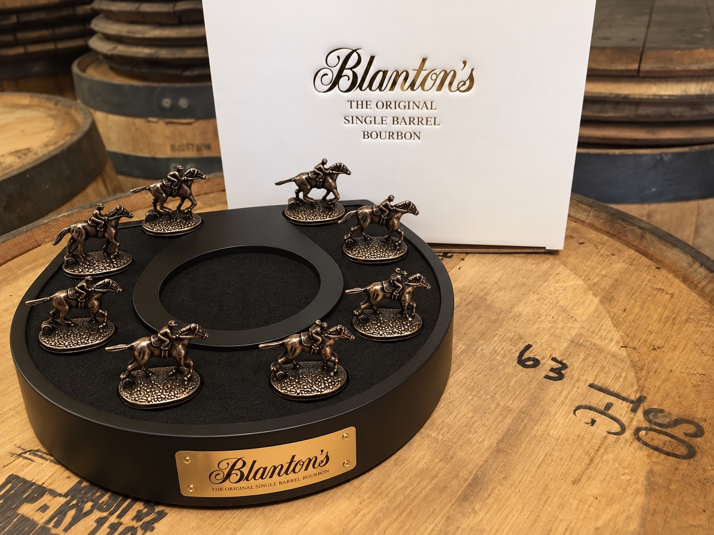 Horseshoe-shaped display stand arranged with eight horse-and-jockey stoppers and an empty center