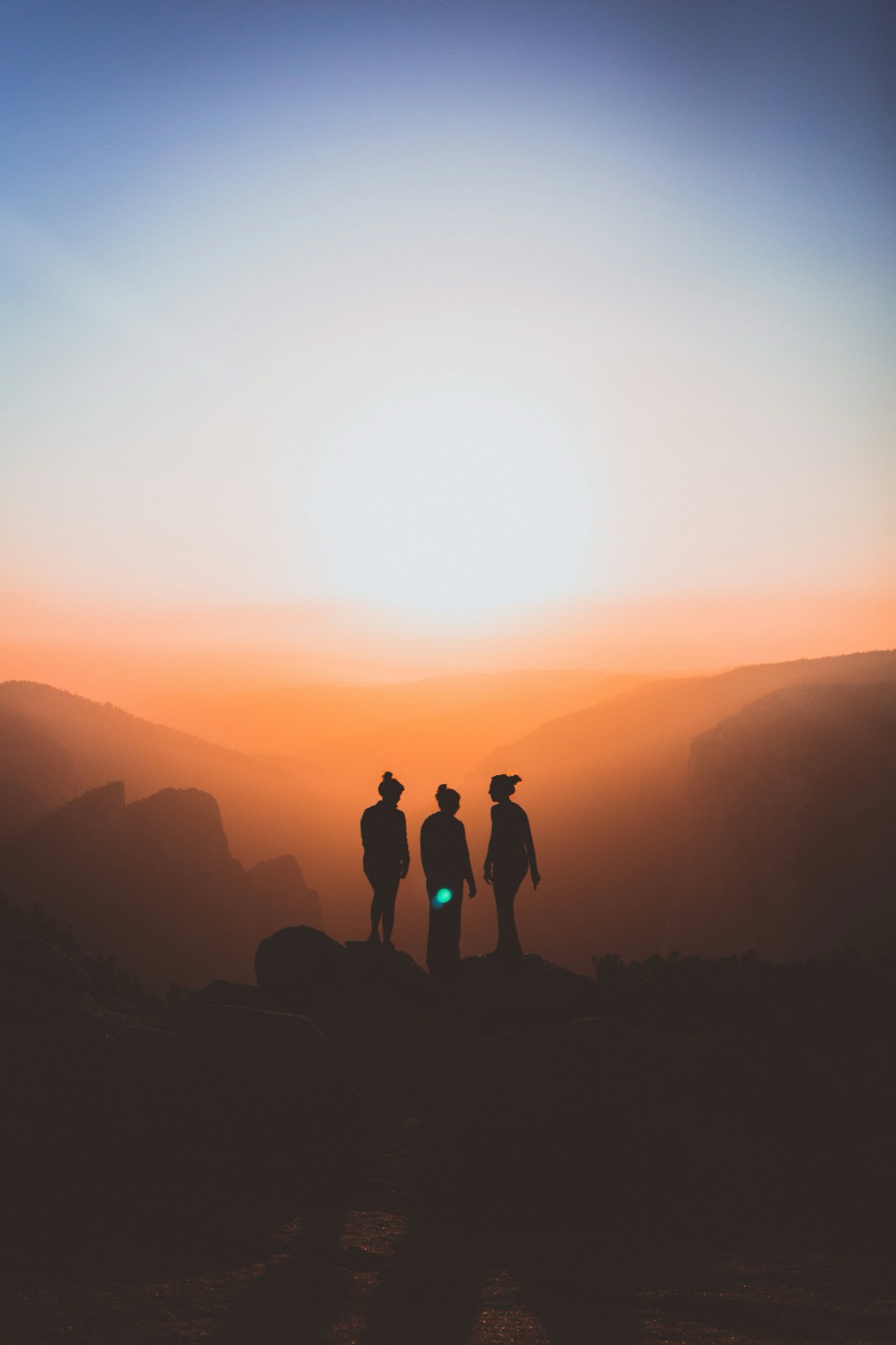 Three people silhouetted against a sunset