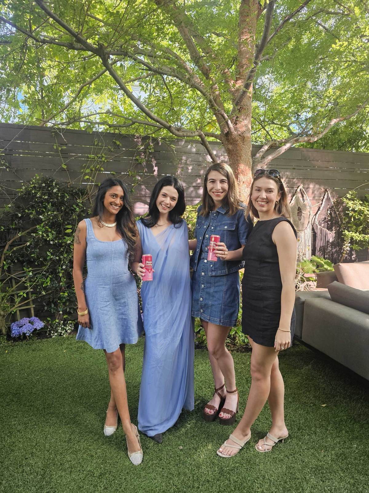 Four women holding Hippie Energy cans