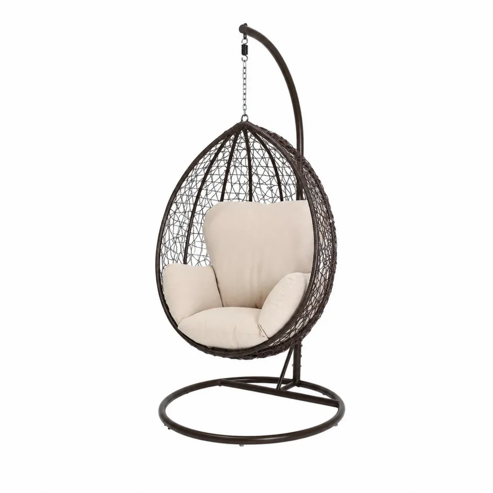 Silla colgante de mimbre con cojines beige y base de acero marrón