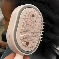 Replace with a square close-up of the comb releasing a fine mist evenly onto mid-length hair while brushing