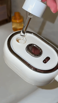 Replace with a vertical GIF or image sequence demonstrating fill the tank, spray while combing, and massage the scalp