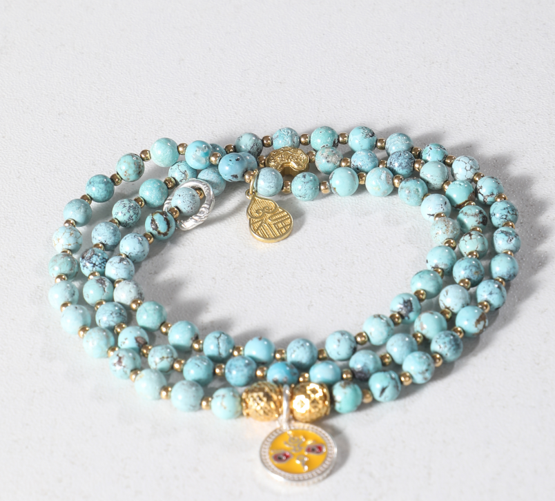 PRODUCT HIGHLIGHT BULLETS Personalized with your name Prepared in a traditional Tibetan blessing ritual Natural red agate and turquoise Gold-plated silver lucky charms Handmade premium craftsmanship Luxury gift box included