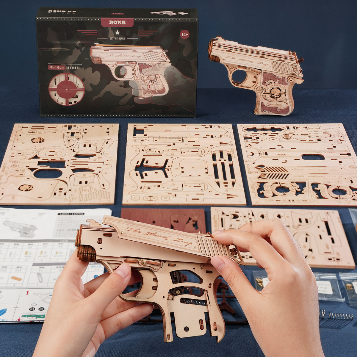 Scène d'assemblage du ROKR Mini Gun LQ502 avec fiches de pièces et boîte de produit