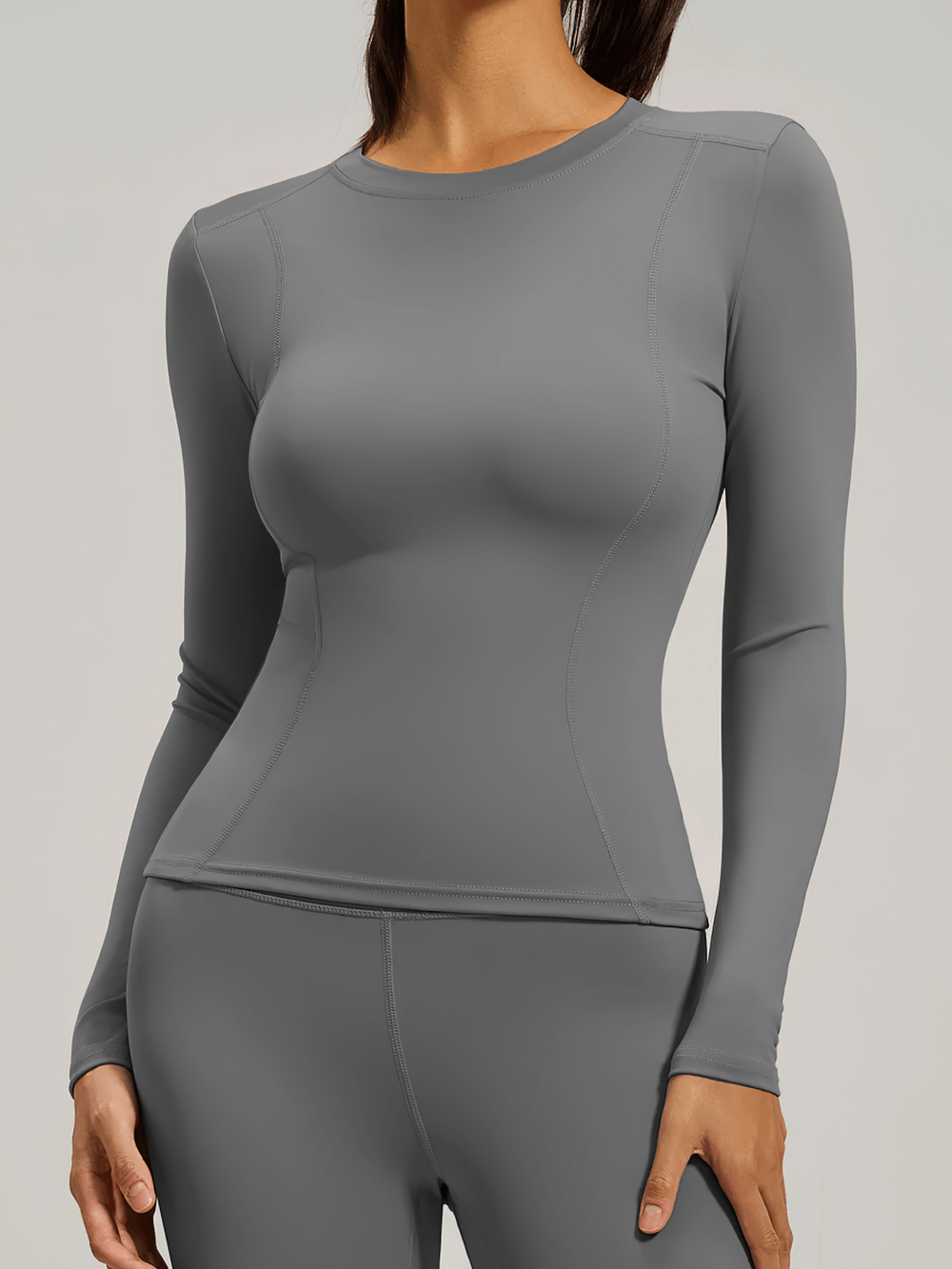 Woman wearing black long-sleeve yoga top, ideal for fitness and yoga sessions.