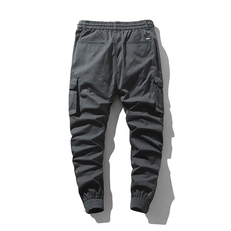 Stylish solid-color cargo pants featuring an elastic drawstring design, multiple pockets, and multiple flap details