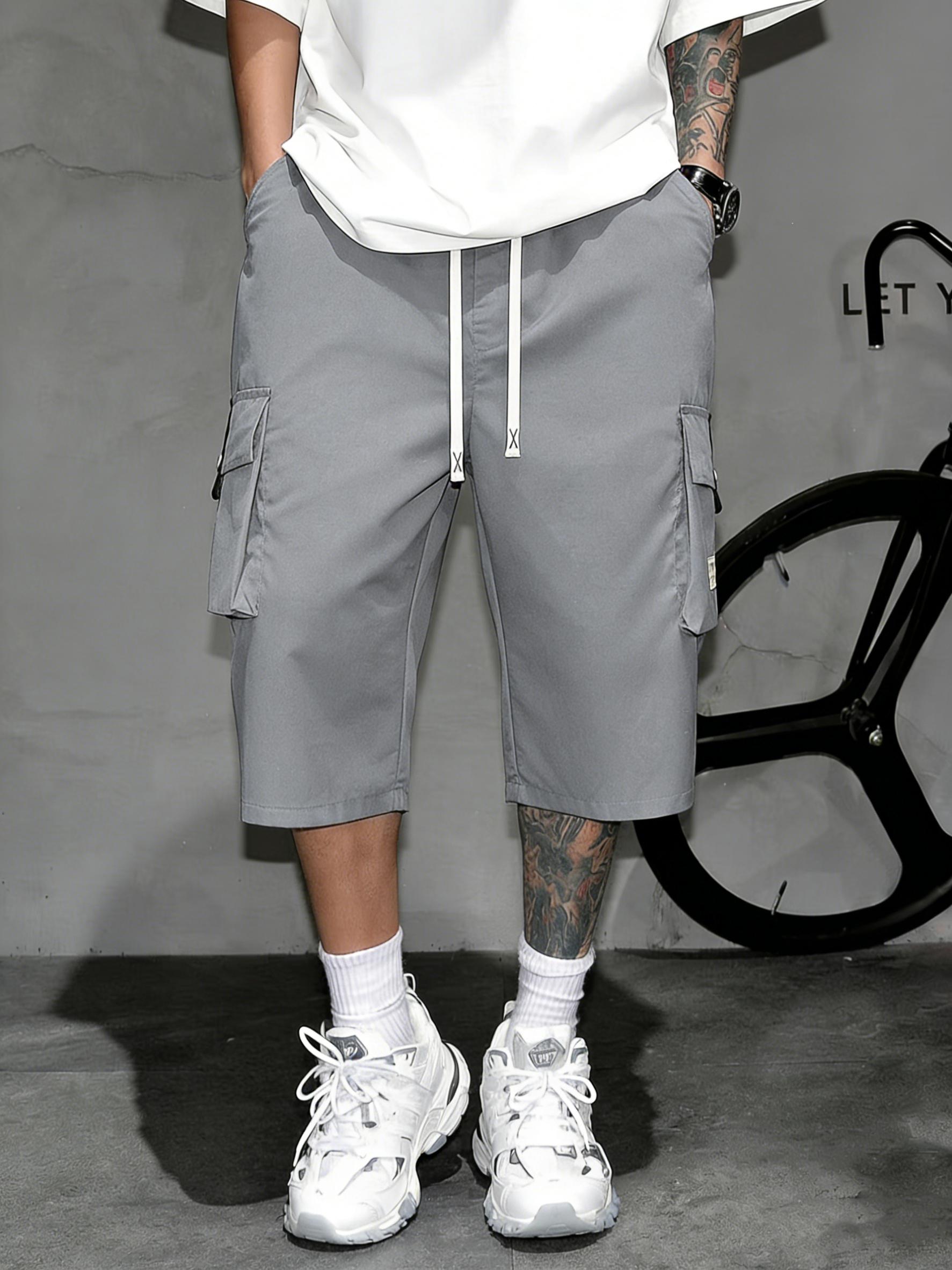 Men’s cargo shorts—knee-length tactical work shorts with multiple pockets and a street-style casual design for summer. Features an elastic waistband with drawstring, pocket patch appliqué design, and is very comfortable to wear.