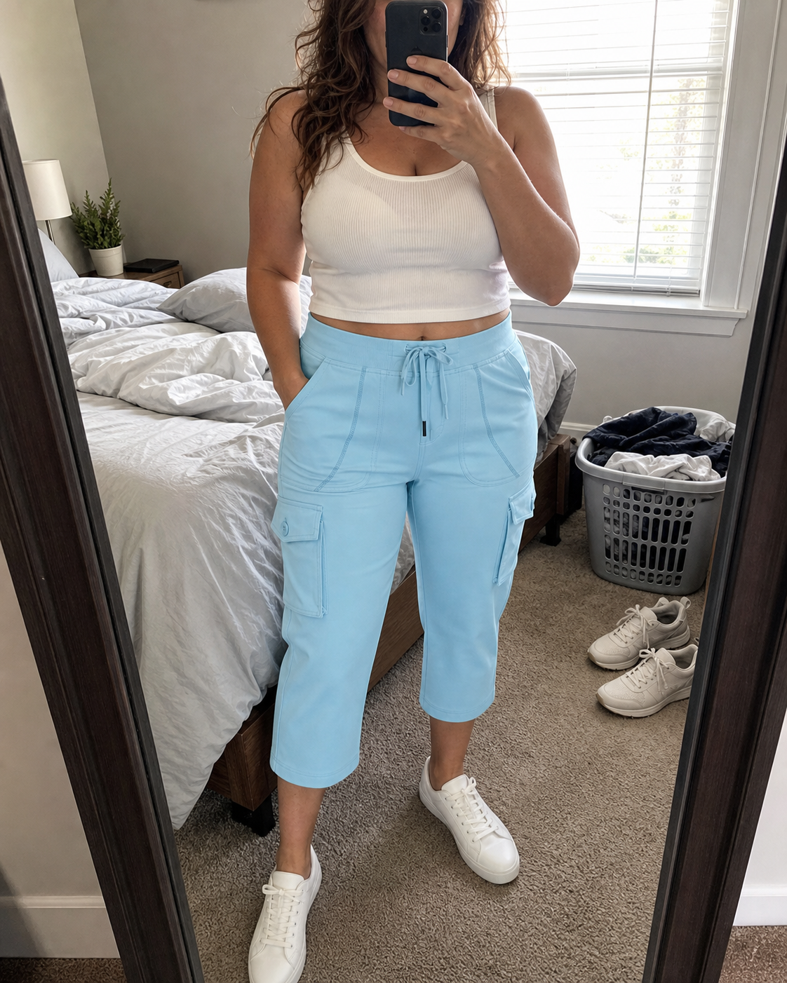 Lauren, a midsize woman, wearing Sky Blue stretch cargo capri pants in a lived-in bedroom mirror selfie
