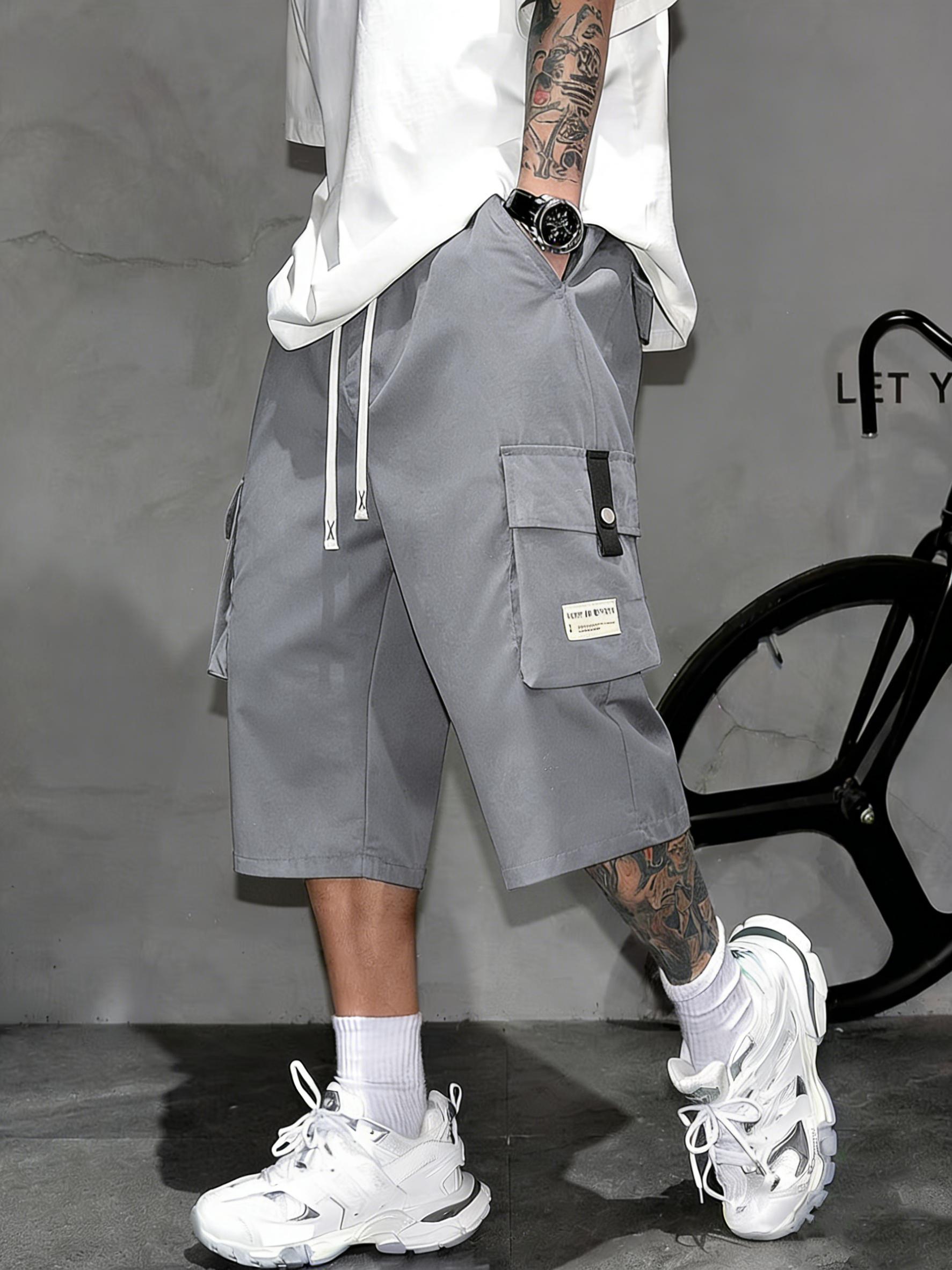 Men’s cargo shorts—knee-length tactical work shorts with multiple pockets and a street-style casual design for summer. Features an elastic waistband with drawstring, pocket patch appliqué design, and is very comfortable to wear.