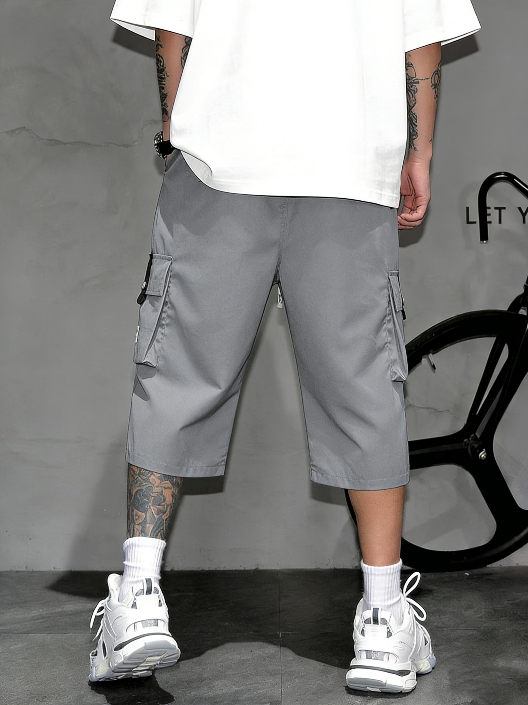 Men’s cargo shorts—knee-length tactical work shorts with multiple pockets and a street-style casual design for summer. Features an elastic waistband with drawstring, pocket patch appliqué design, and is very comfortable to wear.