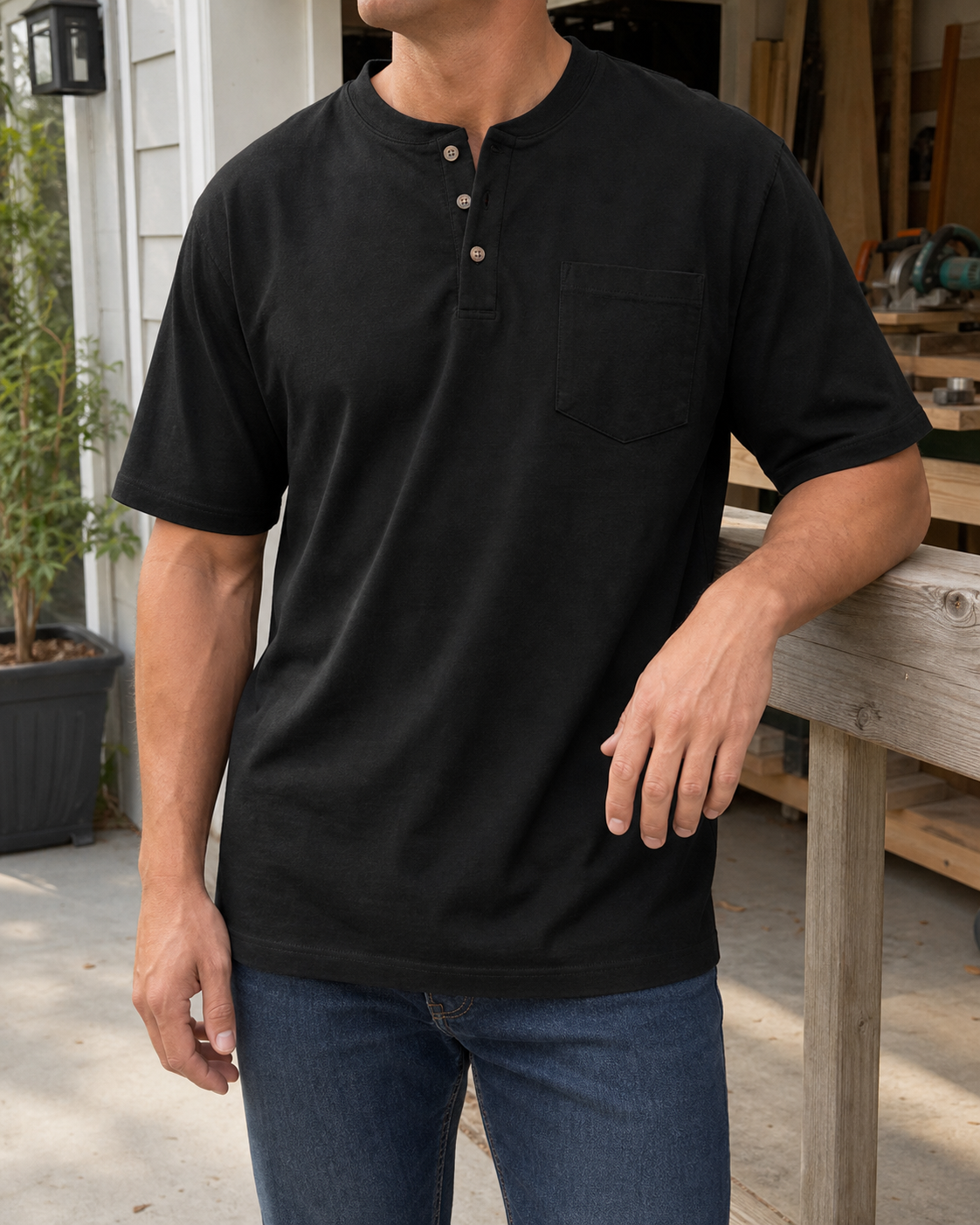 Athletic model wearing the black three-button pocket Henley at a sunlit workshop patio