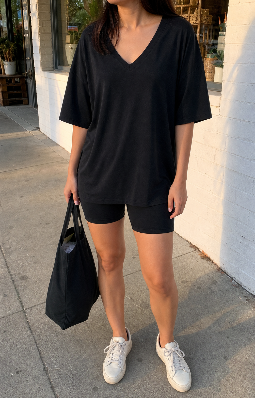 Petite model wearing the black V-neck tee and biker shorts set