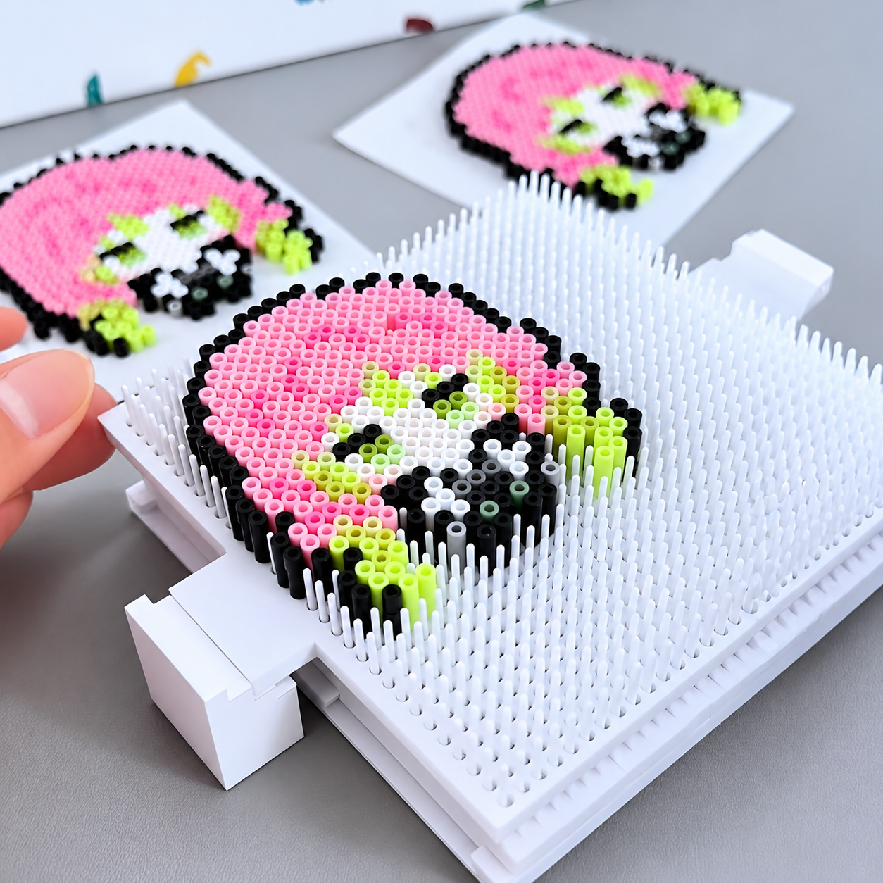 Raised white pegboard with a colorful fuse bead pattern in progress
