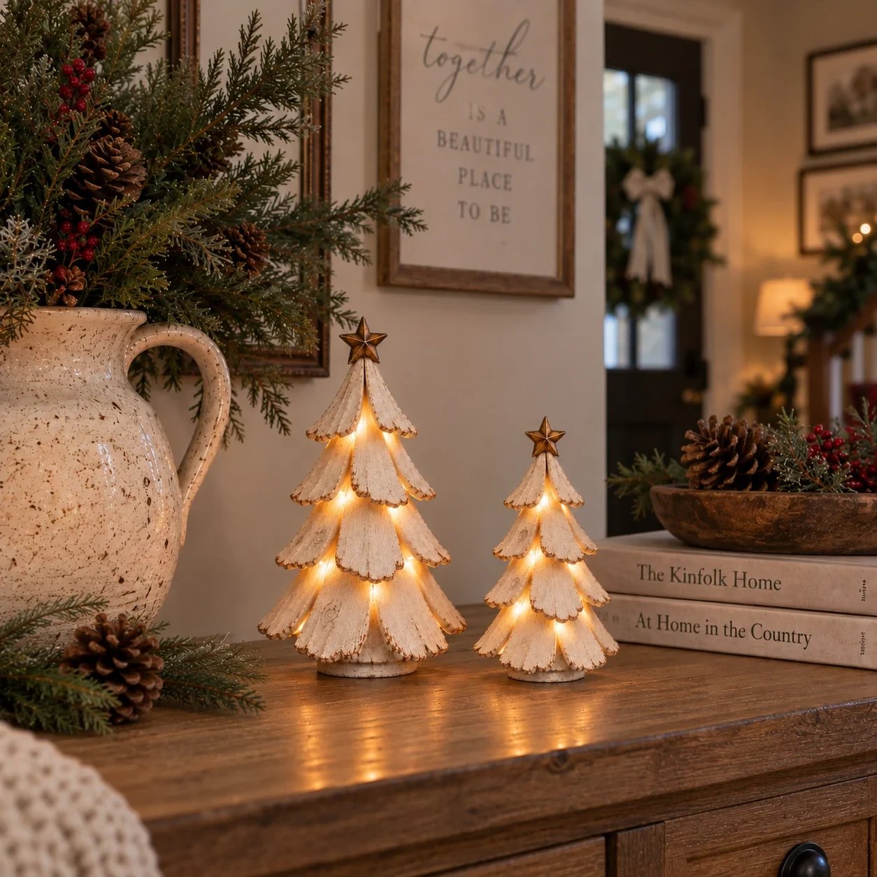 Vintage lighted Christmas tree figurines glowing on a warm farmhouse console