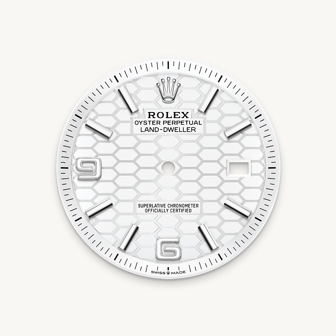 A close-up of a white watch dial featuring hexagonal patterns, silver hour markers, and the Rolex logo.