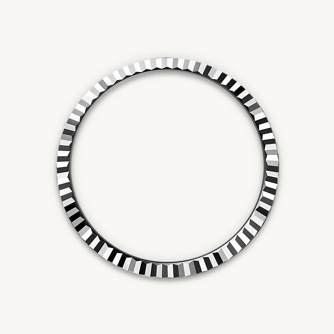 A circular metallic ring with a patterned edge, featuring alternating black and silver segments.