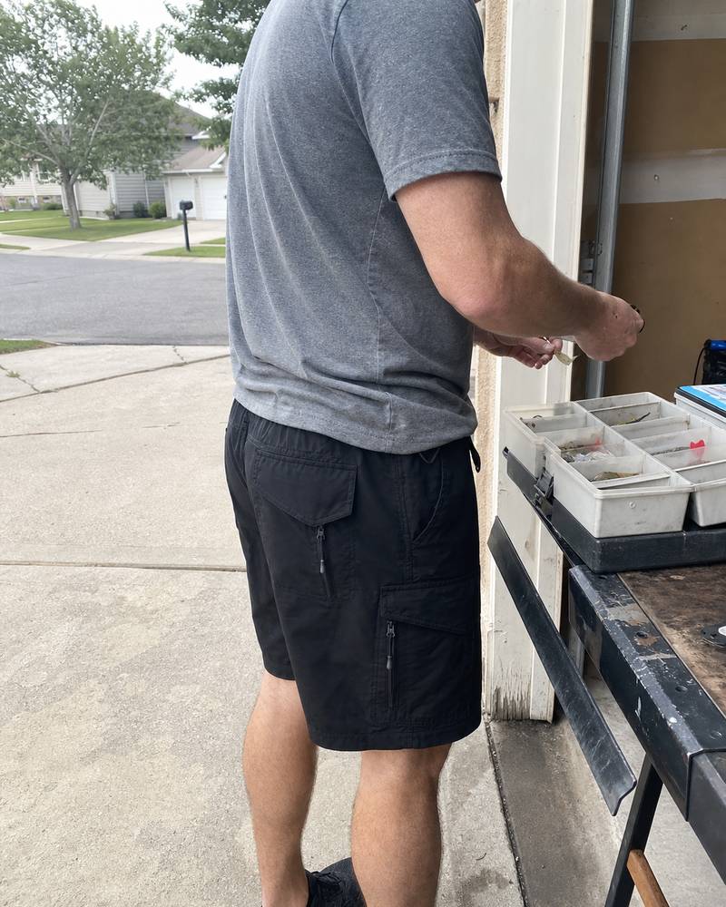 Water-repellent tactical cargo shorts photographed beside an open car trunk