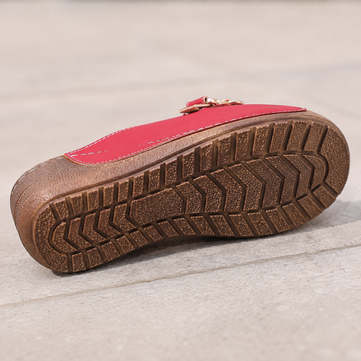 Suggested image: outsole close-up showing anti-slip tread pattern on pavement or indoor tile