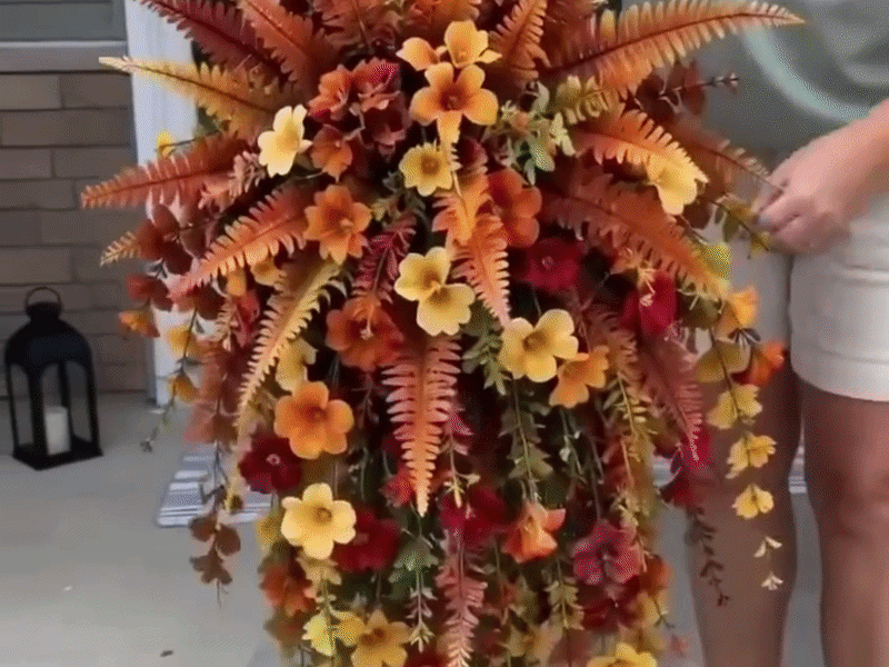 Close-up of hands gently shaping flexible foliage and turning blooms outward after unboxing