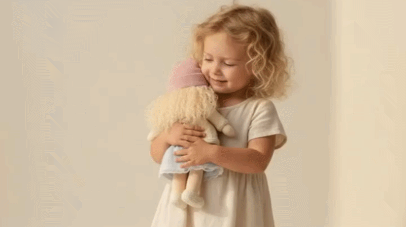 Suggested image: child holding the Serendity handmade Waldorf doll in a warm naturally lit playroom