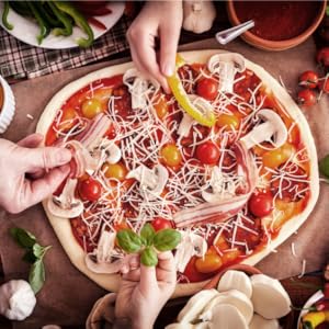 Vue aérienne d'une pizza sur une planche de bois avec plusieurs mains tendues pour ajouter des garnitures, montrant la préparation des aliments en collaboration.