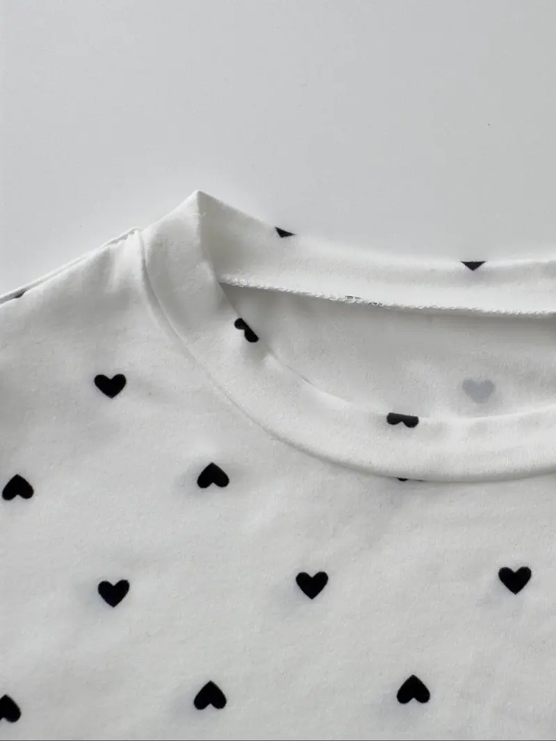 Close view of round neckline and tiny heart print
