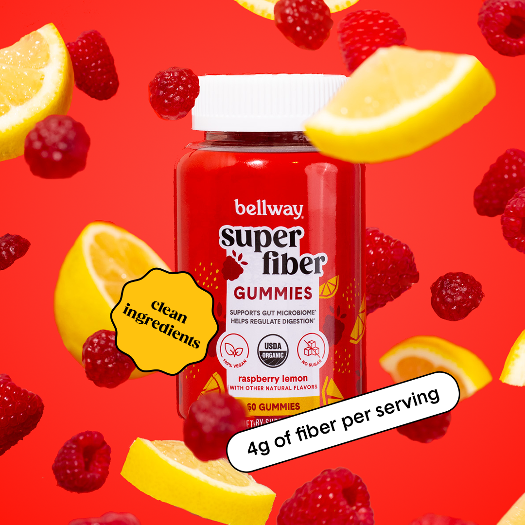 A SUPERFIBER Gummies bottle among fresh raspberries and lemon slices