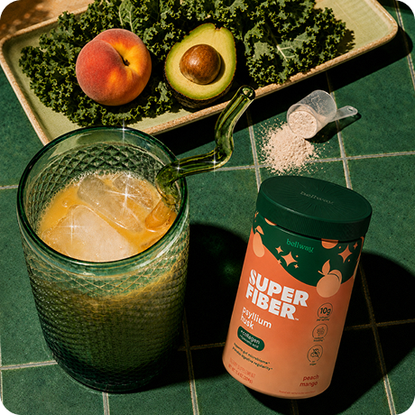 Peach mango Super Fiber mixed over ice beside fresh fruit