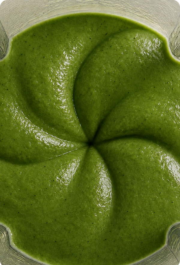 A green smoothie swirled in a blender jar