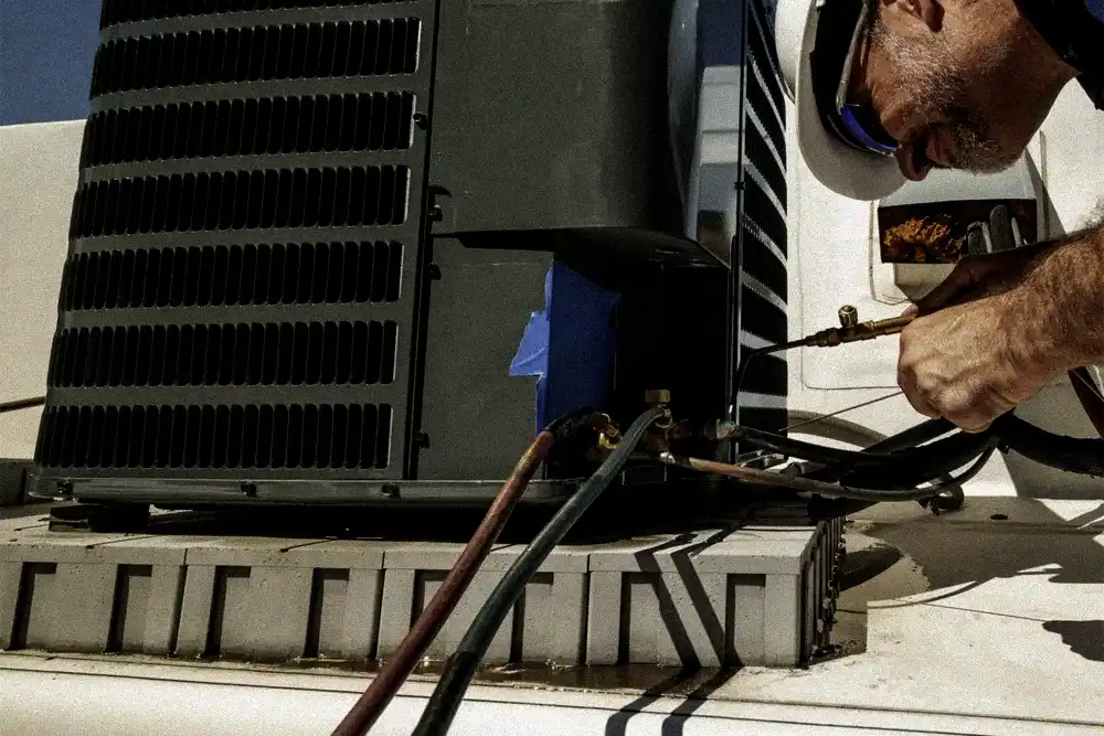 HVAC technician checking an air conditioner refrigerant leak during service