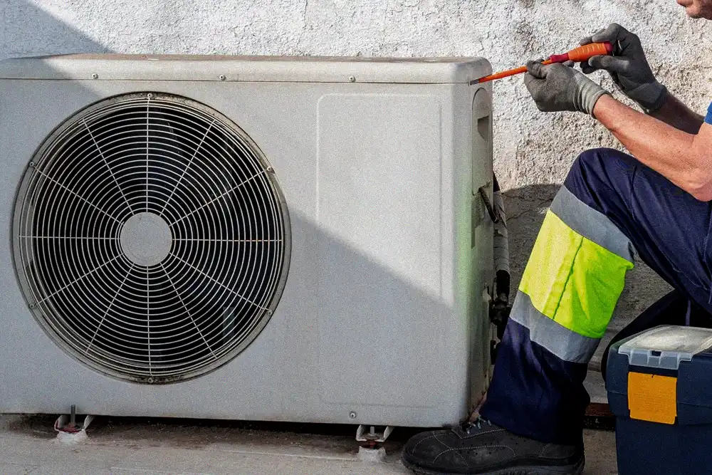 HVAC technician preparing an outdoor AC unit before a heat wave