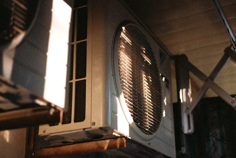 Close-up of a residential outdoor air-conditioning condenser on a sunny day