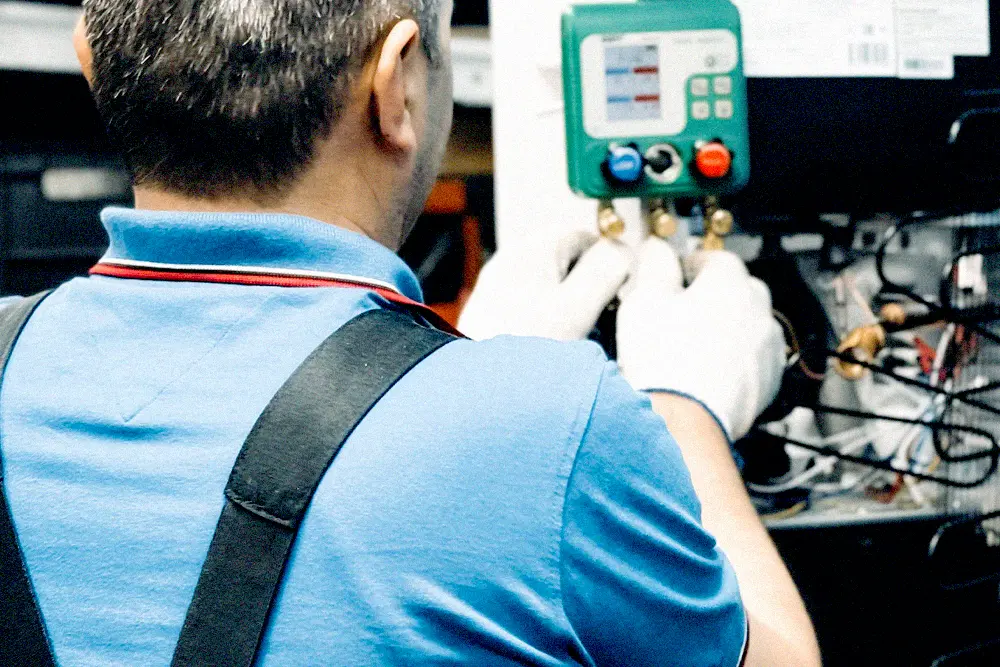 HVAC technician performing maintenance on indoor air-conditioning equipment
