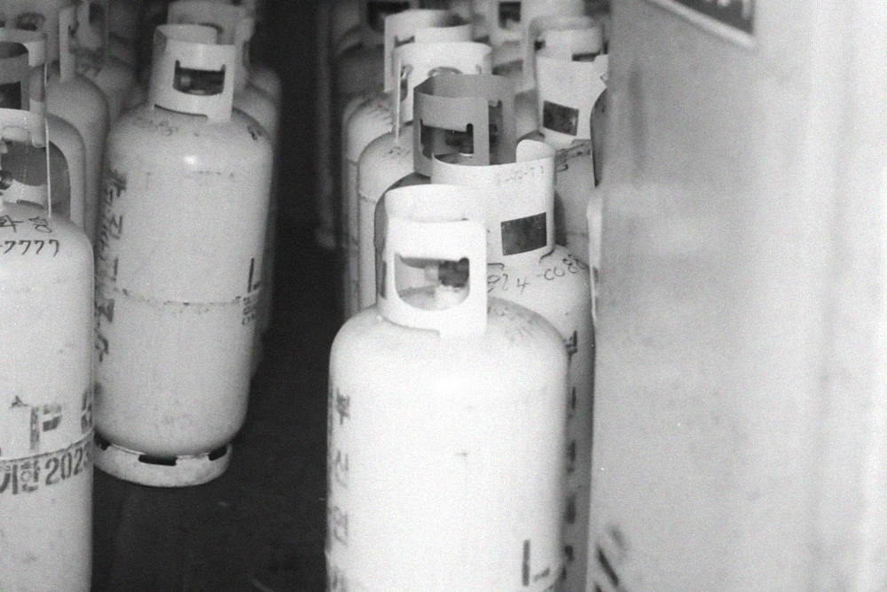 Rows of industrial gas cylinders stored upright in a designated storage area