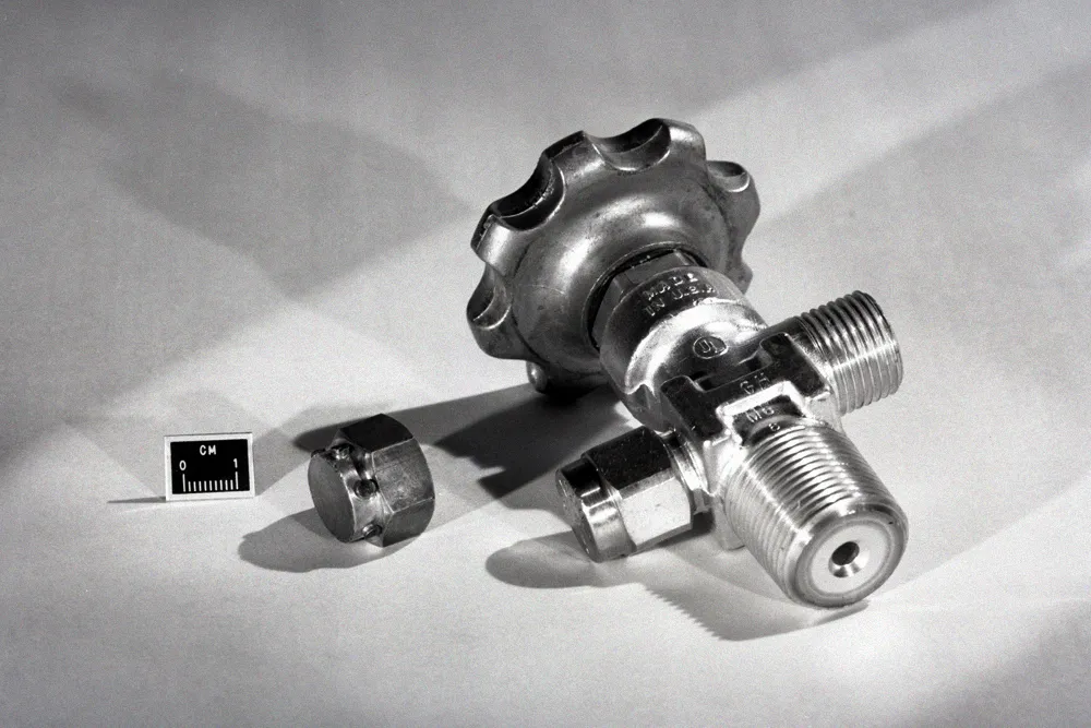 Close-up of a high-pressure gas cylinder valve and relief assembly