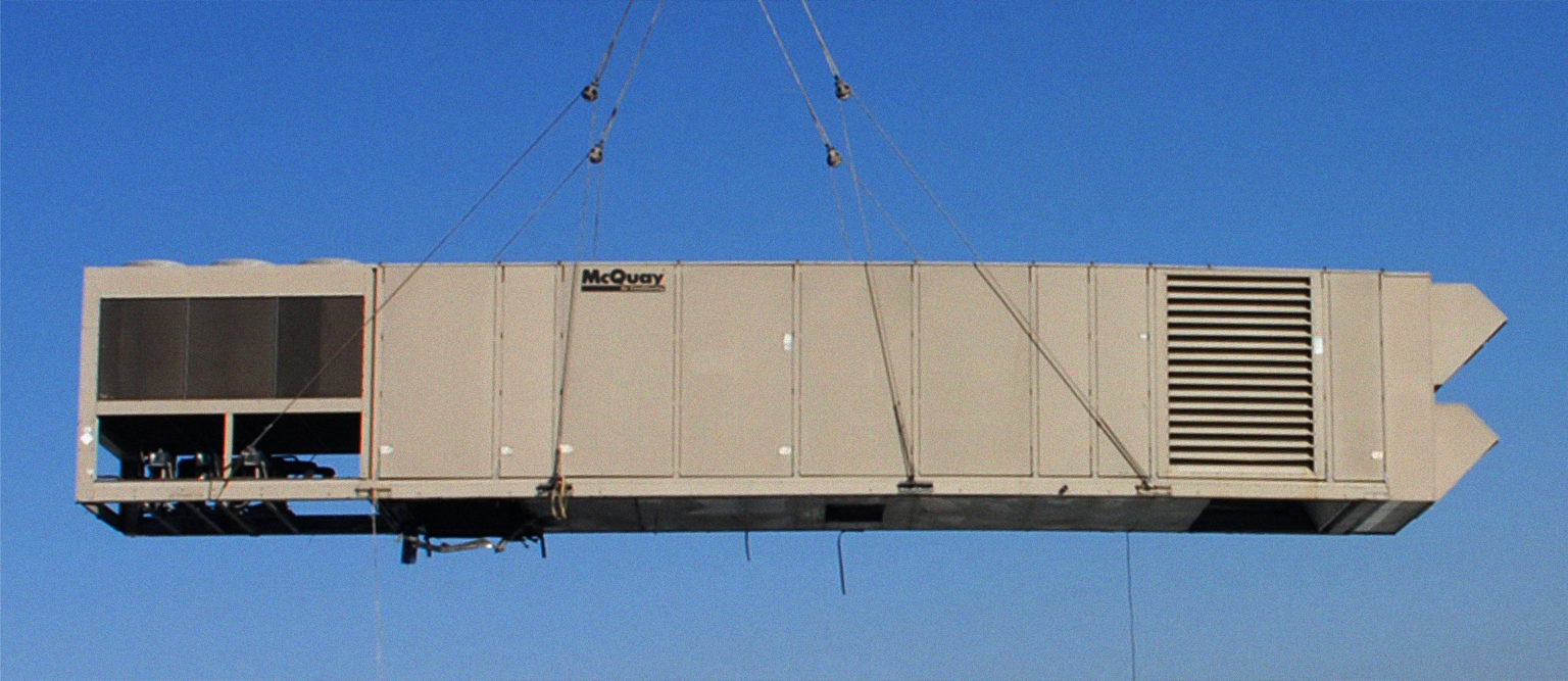 Commercial rooftop air-handling unit being lifted into position