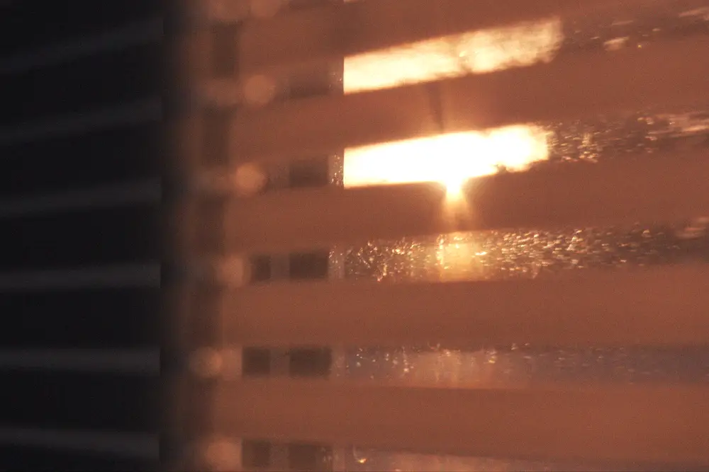 Bright summer sunlight passing through closed window blinds
