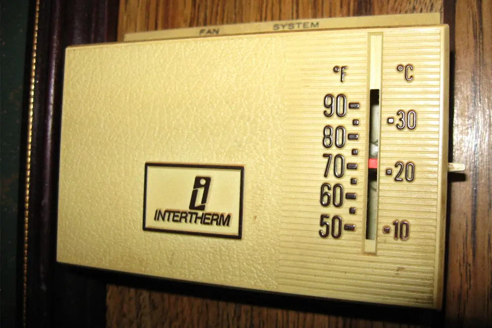 Older mechanical wall thermostat used with a central HVAC system